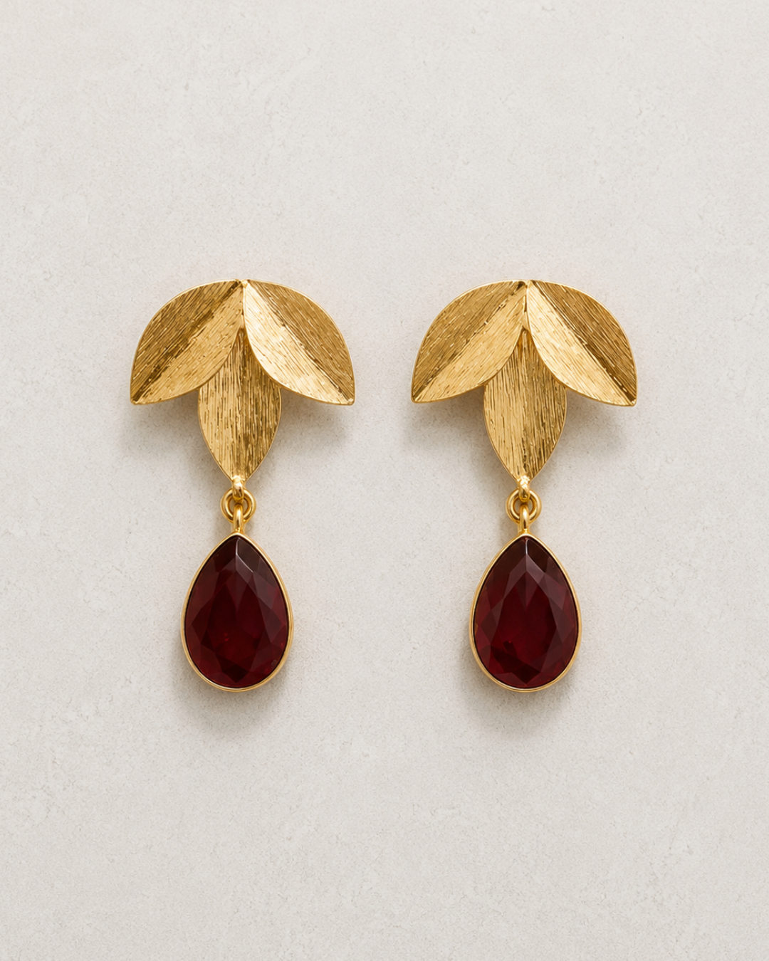 Pendientes Hera dorados con gota de cristal facetado burdeos