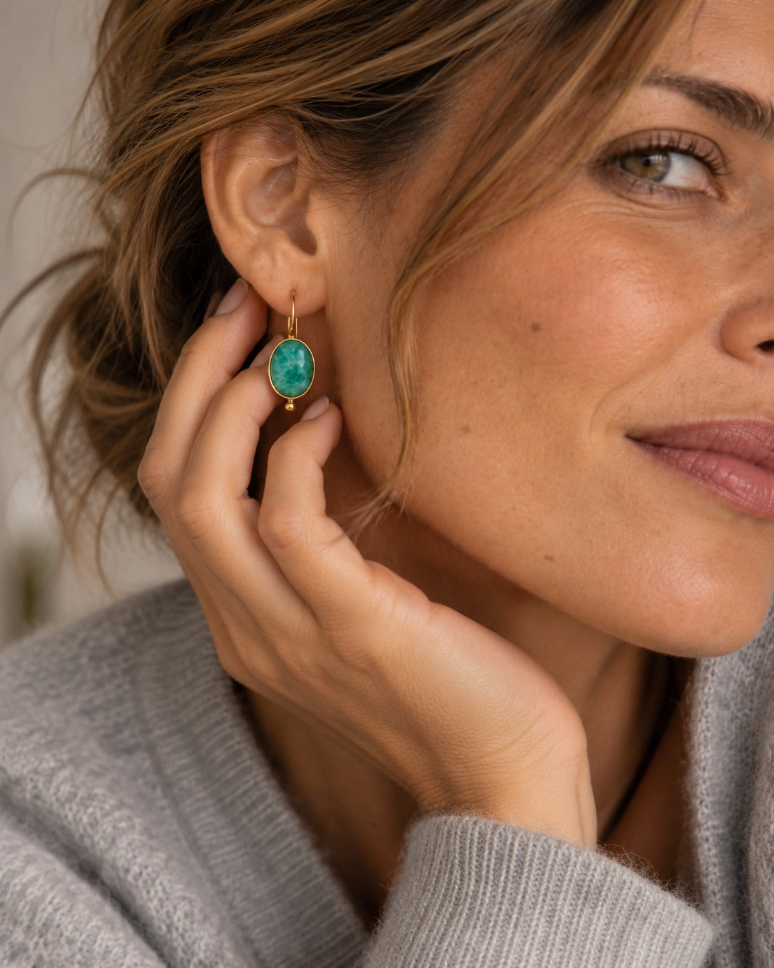 Pendientes Fiorella con piedra verde puestos en modelo, detalle