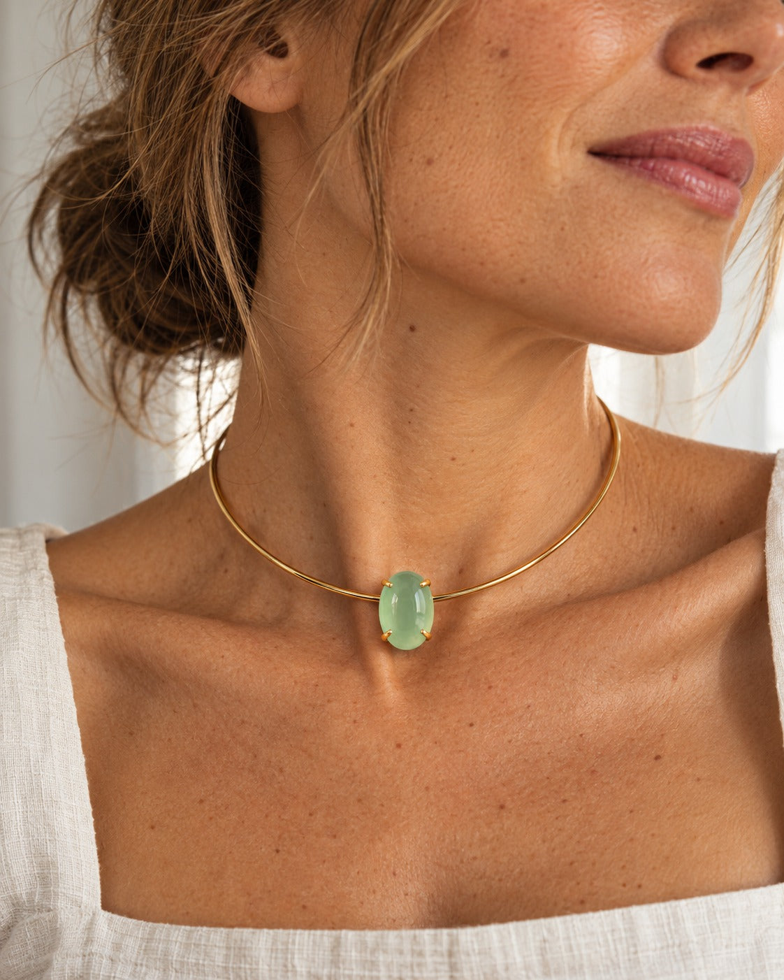 Collar Louise rígido dorado con piedra verde menta puesto en modelo
